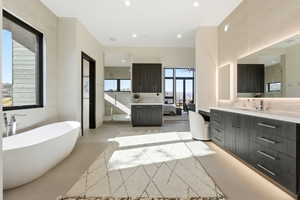 Bathroom with a freestanding tub, two vanities, recessed lighting, ceiling fan, and concrete floors