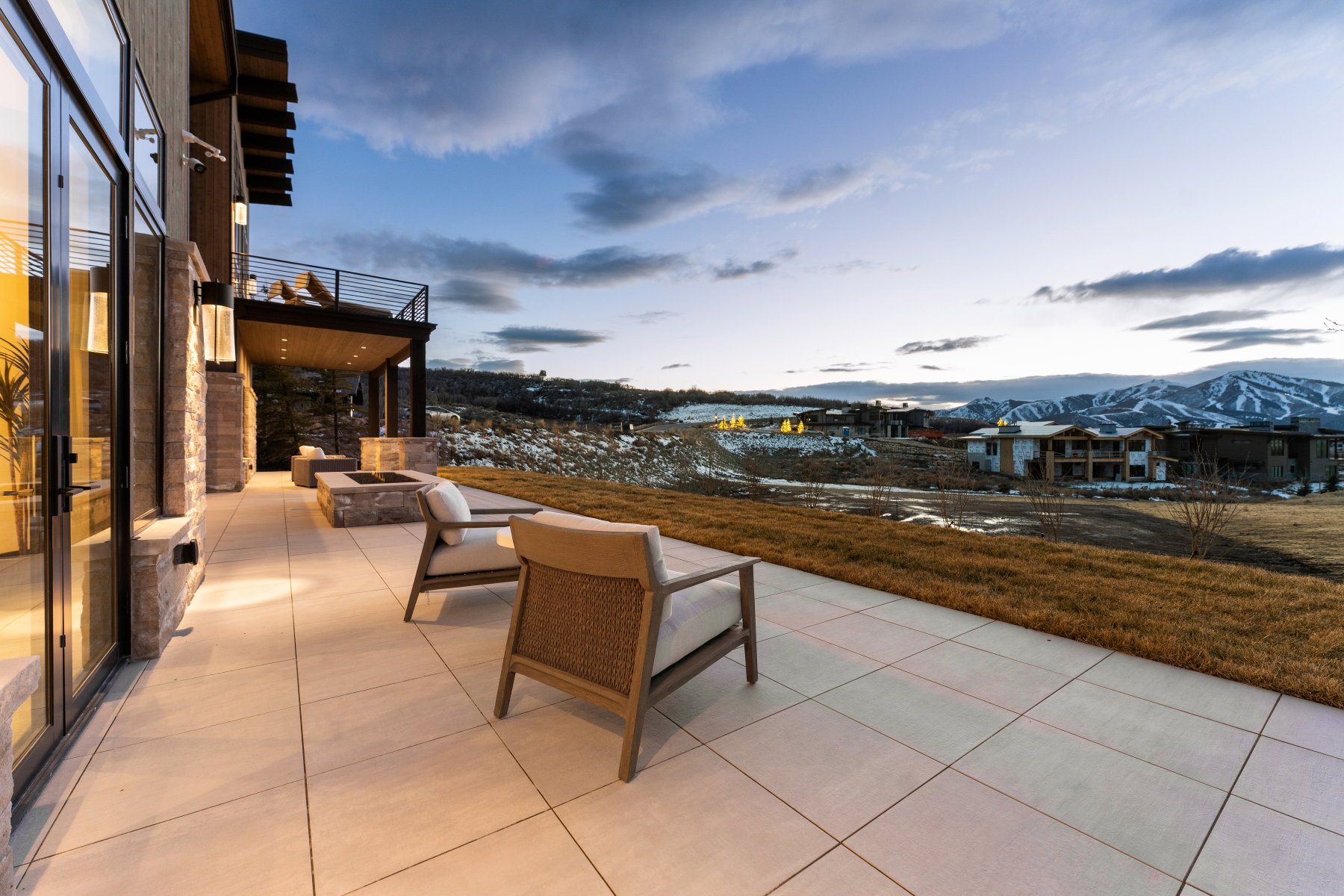 Patio terrace at dusk with a fire pit, a mountain view, and a patio area