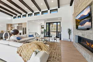 Living area featuring a fireplace, light wood finished floors, recessed lighting, and vaulted ceiling