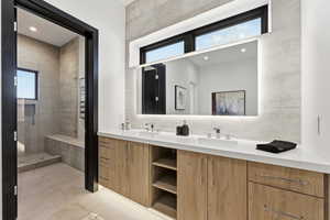Full bath featuring healthy amount of natural light, double vanity, a shower stall, and backsplash