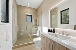 Full bathroom featuring vanity, a stall shower, and tile walls
