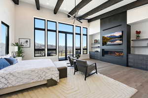 Bedroom with a fireplace, hardwood / wood-style flooring, and ceiling fan