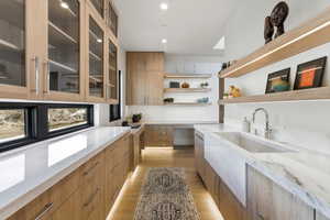 Kitchen featuring modern cabinets, light stone counters, light wood-type flooring, wood finish cabinets, and recessed lighting