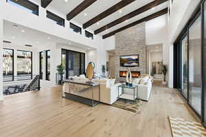Living room featuring a fireplace, lofted ceiling, and light wood-style floors