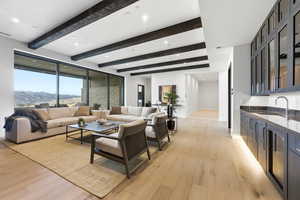 Living room featuring light wood-style flooring, a mountain view, recessed lighting, and beamed ceiling