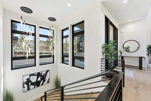 Stairway featuring wood finished floors and recessed lighting