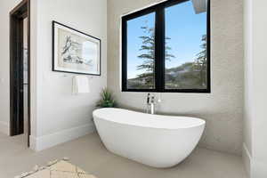 Bathroom with a freestanding tub and light tile patterned floors
