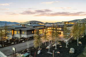 View of front of house with a mountain view, solar panels, stone siding, and a chimney