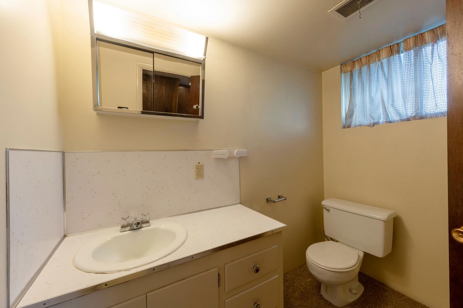 Half bath featuring vanity and backsplash