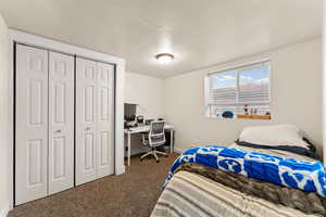 Carpeted bedroom featuring a desk and a closet