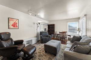 Living room with wood finished floors and rail lighting