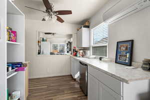 Kitchen featuring light countertops, white cabinetry, healthy amount of natural light, and wood walls