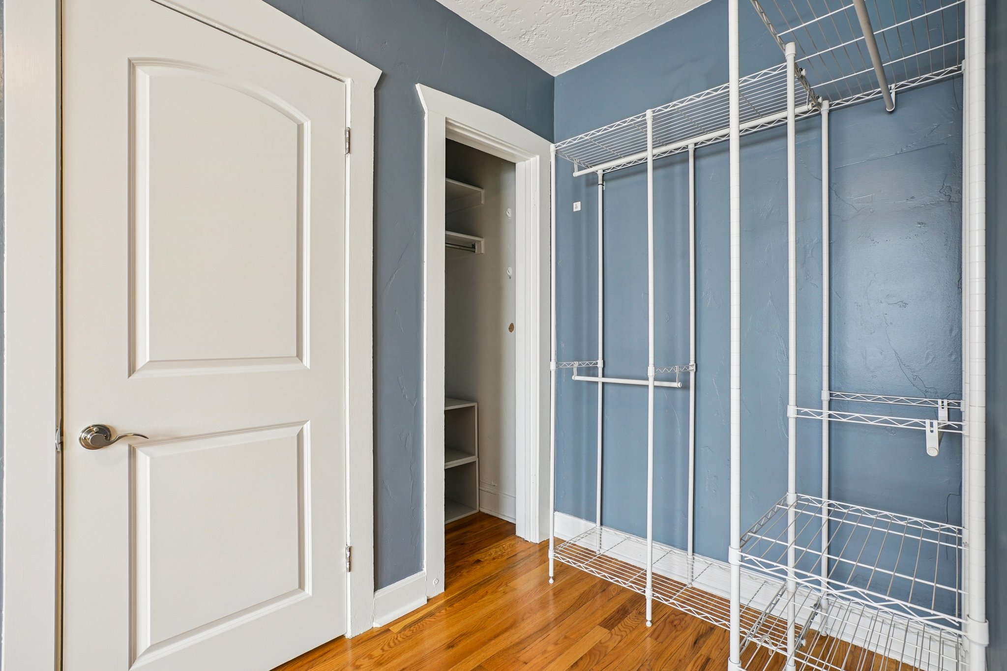 Unfurnished bedroom with light wood finished floors, a textured ceiling, and a closet
