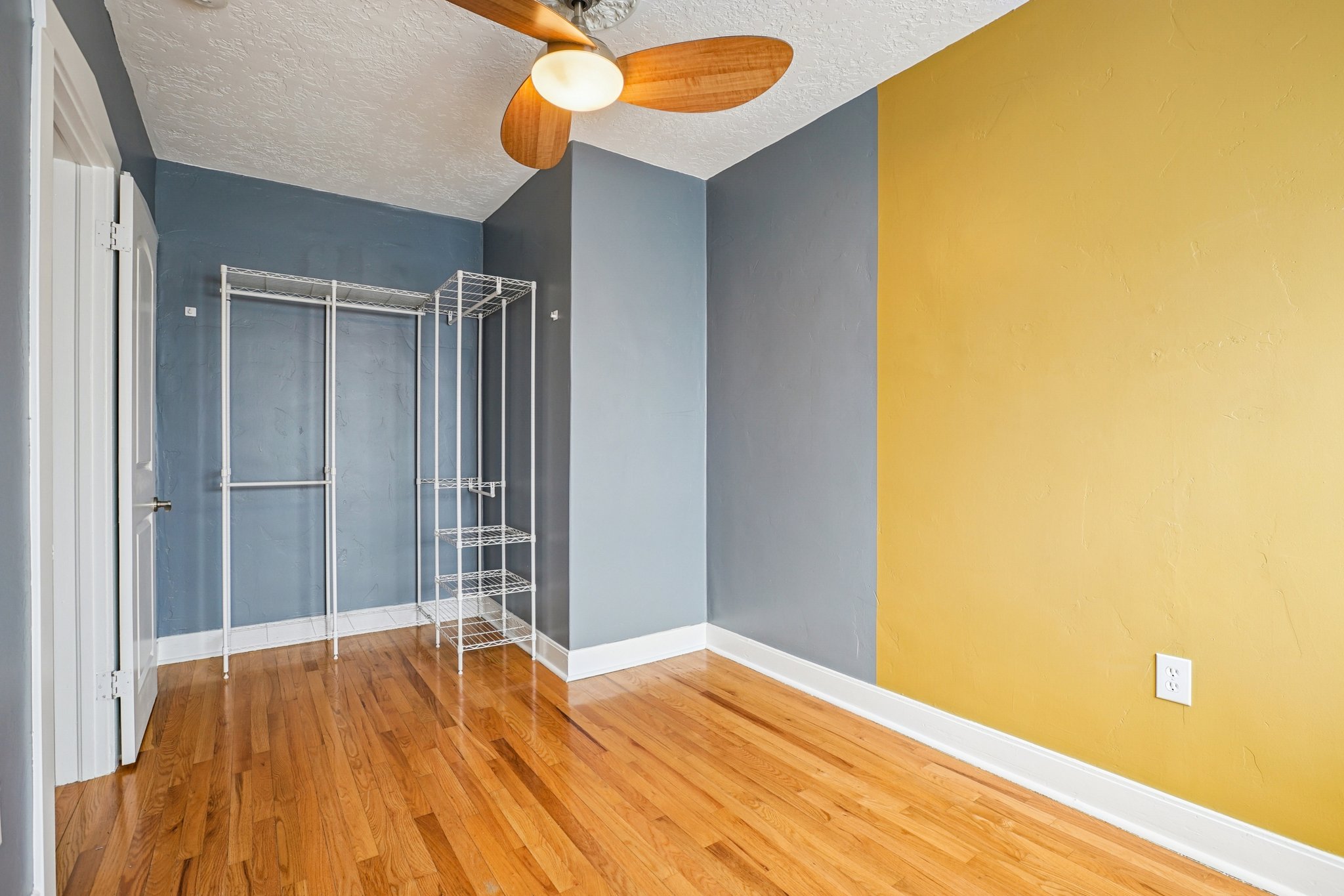 Unfurnished bedroom featuring light wood-style floors, a ceiling fan, and a textured ceiling