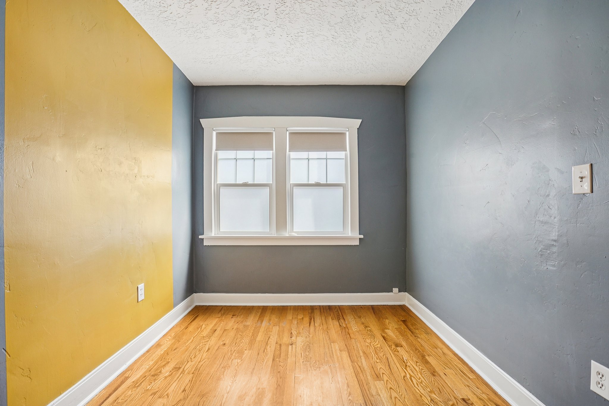 Spare room with light wood finished floors and a textured ceiling