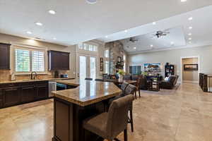 Bedroom with recessed lighting, ceiling fan, dark colored carpet, and a tray ceiling