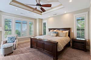Bedroom with recessed lighting, ceiling fan, dark colored carpet, and a tray ceiling