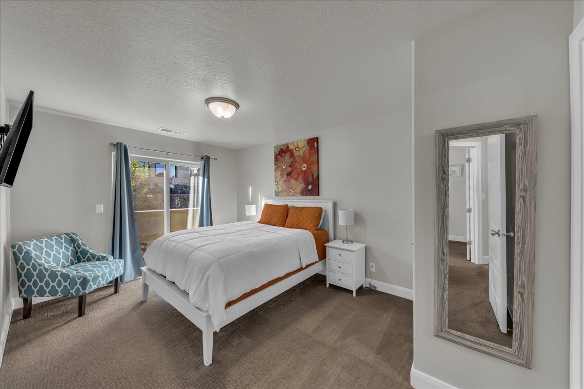 Carpeted bedroom featuring a textured ceiling and access to outside