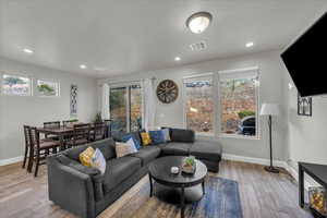 Living room with light wood-style floors, healthy amount of natural light, and recessed lighting