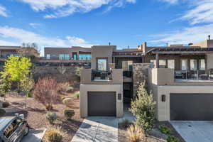 View of front of home featuring stucco siding, a garage, and driveway