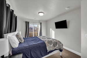 Carpeted bedroom featuring a textured ceiling
