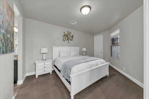 Bedroom with baseboards and dark colored carpet