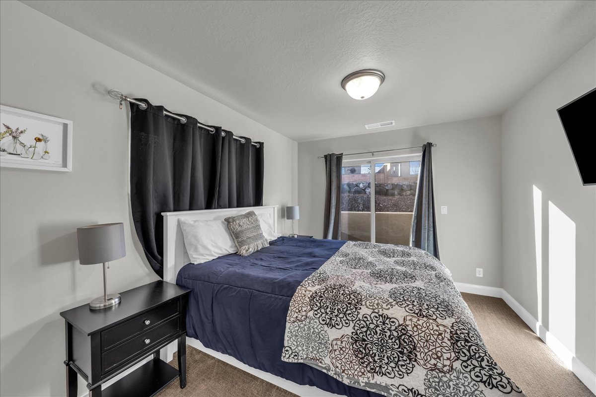 Carpeted bedroom with baseboards and a textured ceiling