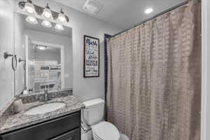 Bathroom with vanity, a shower with curtain, and a textured ceiling