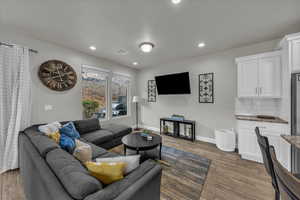 Living area featuring dark wood finished floors and recessed lighting