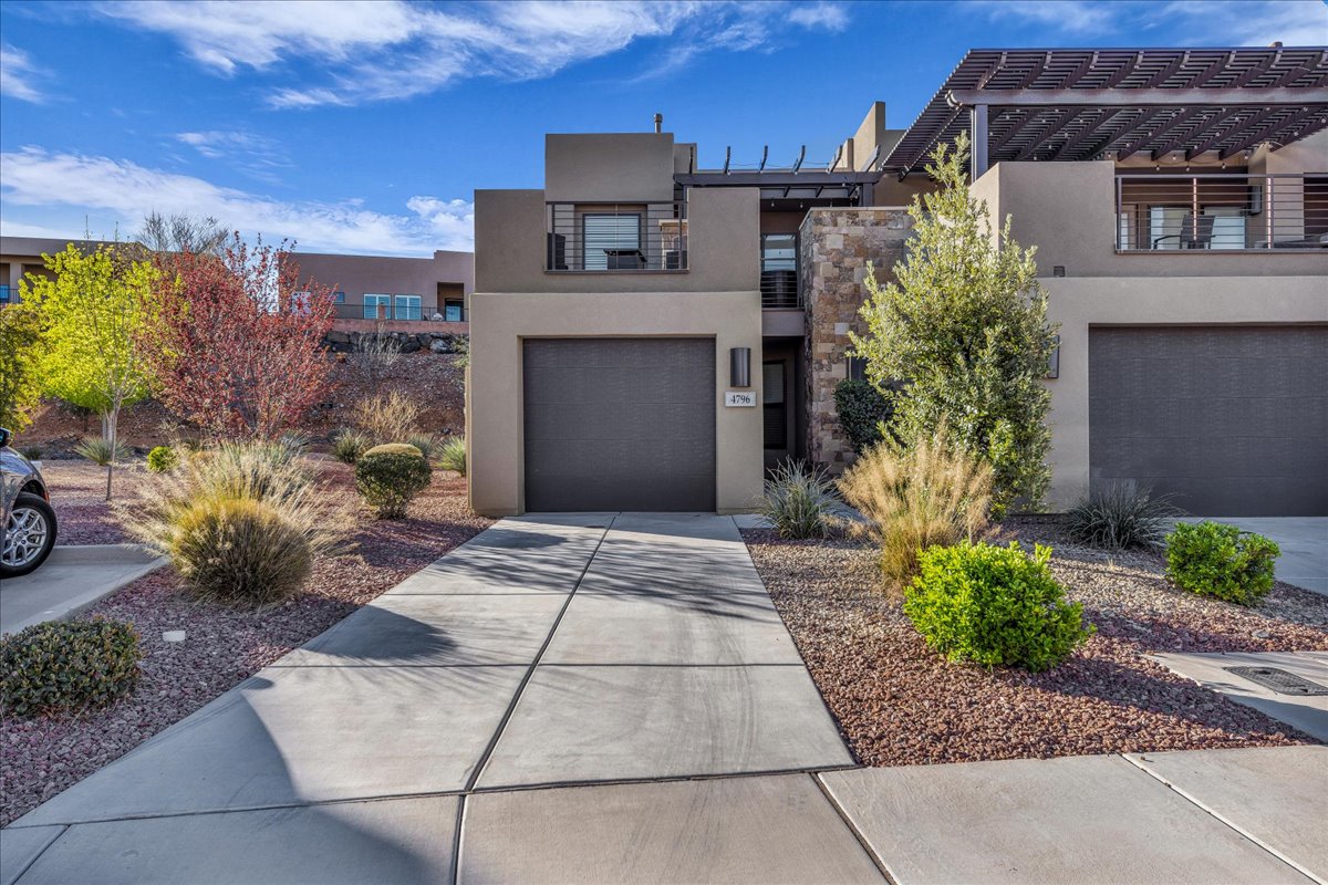 Contemporary house featuring stucco siding, concrete driveway, a garage, and a pergola