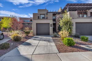 Contemporary house featuring stucco siding, concrete driveway, a garage, and a pergola