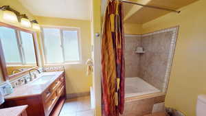 Full bathroom featuring vanity, tiled shower / bath, and light tile patterned flooring