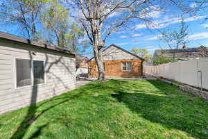 Rear view of property with a patio area, mature trees, and nearly-full fencing