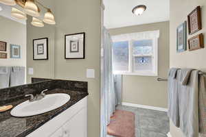 Full Bathroom with vanity, curtained shower, and storage