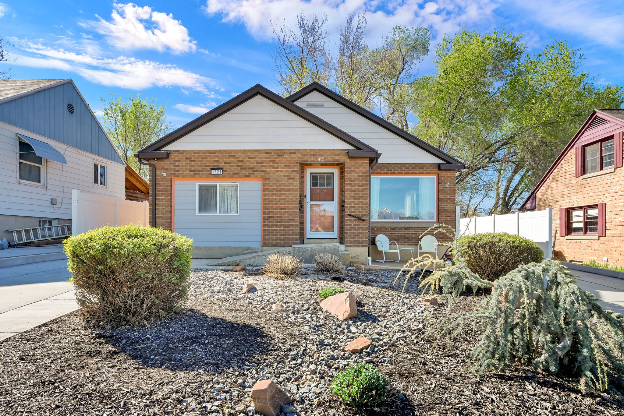Bungalow-style home with brick siding, xeriscaped front-yard, and ramp entrance for accessibility