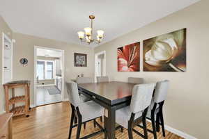 Semi-formal dining space featuring wood flooring and a chandelier