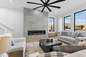Living room featuring wood finished floors, a tiled fireplace, and recessed lighting