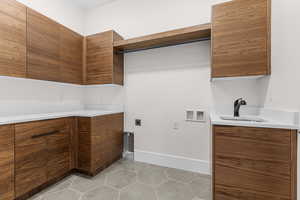 Laundry area with light tile patterned flooring, electric dryer hookup, washer hookup, and cabinet space