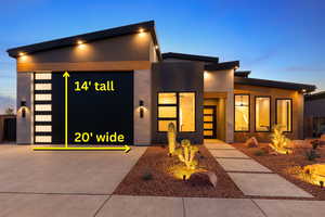 View of front of property with an attached garage, driveway, and stucco siding