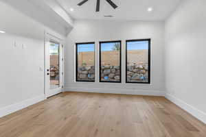Unfurnished room featuring light wood-type flooring, plenty of natural light, ceiling fan, recessed lighting, and vaulted ceiling
