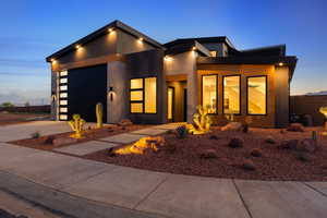 Contemporary home featuring a garage, concrete driveway, and stucco siding
