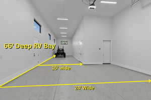 Garage featuring baseboards and a garage door opener