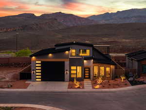 Contemporary house with a mountain view, stucco siding, driveway, and a garage