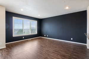 Spare room with dark wood finished floors, recessed lighting, and a textured ceiling