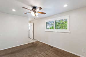 Empty room with light carpet, a ceiling fan, and recessed lighting