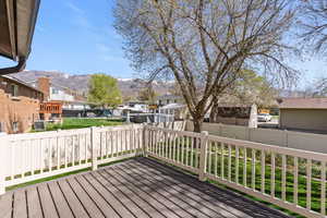 Wooden terrace with a residential view, a fenced backyard, and a mountain view