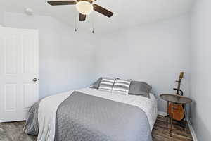 Bedroom featuring ceiling fan and dark wood-type flooring