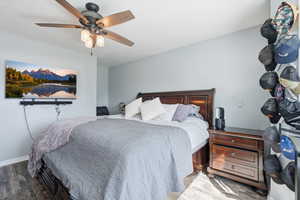 Bedroom featuring wood finished floors, a ceiling fan, and a mountain view
