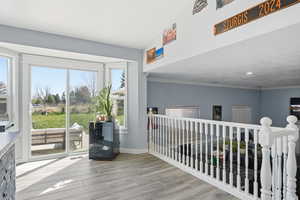 Corridor featuring light wood-style floors and crown molding