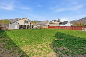 Fenced backyard featuring a mountain view and a patio
